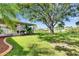 Spacious backyard featuring lush grass, mature trees, and a screened in lanai for comfortable outdoor living at 318 Lookout Dr, Apollo Beach, FL 33572