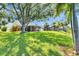 Expansive backyard with lush lawn, mature trees, and a screened in lanai; ideal for outdoor relaxation and entertainment at 318 Lookout Dr, Apollo Beach, FL 33572