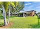 Lush backyard with well-maintained lawn, mature trees, and a screened in lanai that offers an inviting outdoor living space at 318 Lookout Dr, Apollo Beach, FL 33572