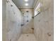 The beautifully tiled shower has a rain shower head, handheld, and corner shelves at 318 Lookout Dr, Apollo Beach, FL 33572