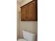 Bathroom features a toilet underneath a set of wooden cabinets with dark bronze fixtures at 318 Lookout Dr, Apollo Beach, FL 33572