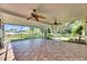 Expansive enclosed tiled patio showing lush landscaping and a fenced yard at 318 Lookout Dr, Apollo Beach, FL 33572