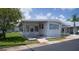 Well-maintained, bright one-story home with white exterior, a covered carport, and a grassy lawn at 3301 Alt 19 # 317, Palm Harbor, FL 34683