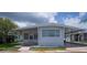 Charming single-story home with a covered carport, well-manicured lawn, and mature trees providing shade at 3301 Alt 19 # 317, Palm Harbor, FL 34683