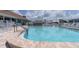 Outdoor swimming pool surrounded by lounge chairs and fencing, with the clubhouse nearby at 3301 Alt 19 # 317, Palm Harbor, FL 34683