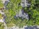 An overhead shot reveals mature trees enveloping a house with a screened-in patio and spacious yard at 344 Cascade Ln, Palm Harbor, FL 34684