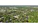 An aerial view of a neighborhood with mature trees and a lake in the distance at 344 Cascade Ln, Palm Harbor, FL 34684