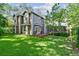 Beautiful backyard with a lush lawn, a wooden deck, a screened porch, and mature trees, perfect for outdoor enjoyment at 344 Cascade Ln, Palm Harbor, FL 34684