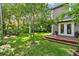 Spacious backyard featuring a wooden deck, lush greenery, and a peaceful seating area around a fire pit at 344 Cascade Ln, Palm Harbor, FL 34684
