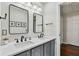 Bathroom featuring double sink vanity, black fixtures, and framed mirrors at 344 Cascade Ln, Palm Harbor, FL 34684