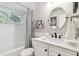 Bright bathroom featuring subway tile, a shower-tub combo, a modern vanity, and a stylish oval mirror at 344 Cascade Ln, Palm Harbor, FL 34684
