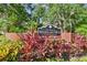 Entrance sign to The Village of Woodland Hills, a Desirable and Restricted Community, surrounded by vibrant landscaping at 344 Cascade Ln, Palm Harbor, FL 34684