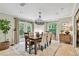 Bright dining room featuring a wood table, six chairs, modern chandelier, and access to outdoor area at 344 Cascade Ln, Palm Harbor, FL 34684