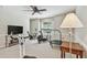 Home gym featuring carpet flooring, various workout machines, a TV, a side table, and a ceiling fan for an engaging workout at 344 Cascade Ln, Palm Harbor, FL 34684