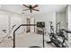 Spacious exercise room with carpet flooring, ceiling fan, several workout machines, and a tv near a hallway door at 344 Cascade Ln, Palm Harbor, FL 34684
