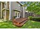 Two-story home features lush landscaping, wooden deck with stairs and convenient access to a screened in porch at 344 Cascade Ln, Palm Harbor, FL 34684