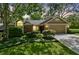 Charming front exterior of the home with a manicured lawn, mature trees, and a two-car garage at 344 Cascade Ln, Palm Harbor, FL 34684