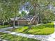 Charming two-story home with a well-maintained lawn, mature trees, a driveway, and a welcoming facade in a suburban setting at 344 Cascade Ln, Palm Harbor, FL 34684