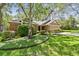 Charming exterior view of the home showcasing well-maintained landscaping, mature trees, and a two-car garage at 344 Cascade Ln, Palm Harbor, FL 34684