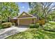 Attached two-car garage featuring brick accents, a paved driveway, and attractive landscaping at 344 Cascade Ln, Palm Harbor, FL 34684