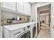 Functional laundry room featuring a modern washer and dryer, white cabinets, shelves, and ample space for laundry tasks at 344 Cascade Ln, Palm Harbor, FL 34684