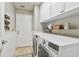 Functional laundry room featuring a modern washer and dryer, white cabinets, shelves, and ample space for laundry tasks at 344 Cascade Ln, Palm Harbor, FL 34684
