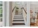 Staircase with hardwood treads and white risers, leading to an upper level with natural light and a plant at 344 Cascade Ln, Palm Harbor, FL 34684