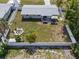 Aerial view of a fenced backyard with a fire pit and seating area, along with an outdoor patio set with umbrella at 3490 57Th St, St Petersburg, FL 33710
