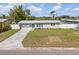 Charming single-story home showcasing a well-manicured lawn and paved driveway, offering great curb appeal at 3490 57Th St, St Petersburg, FL 33710