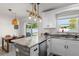 Modern kitchen with white cabinetry, marble countertops, and a rustic rope light fixture at 3490 57Th St, St Petersburg, FL 33710