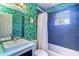 Stylish bathroom with tropical wallpaper, blue tile, and shower-tub combination at 3910 14Th N Ave, St Petersburg, FL 33713