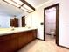 Dual sink vanity with wood cabinets, mirror and open view to separate toilet and shower area at 4006 Huxford Ct, Tampa, FL 33624