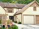 Beige two-story townhome with two car garage, shuttered windows and tidy landscaping at 4006 Huxford Ct, Tampa, FL 33624