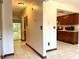 Bright hallway with tiled floor leading to a kitchen with brown cabinets at 4006 Huxford Ct, Tampa, FL 33624