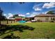 Property featuring a spacious backyard with a small above-ground pool, a barn, and horses grazing in the distance at 408 River Bed Ct, Wimauma, FL 33598