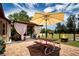 Enjoy the fenced backyard with a brick patio, fire pit, and a covered seating area for outdoor gatherings at 408 River Bed Ct, Wimauma, FL 33598