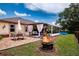 Spacious backyard featuring a fire pit, brick patio, outdoor seating, and a screened-in porch for relaxation at 408 River Bed Ct, Wimauma, FL 33598
