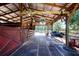 Barn interior with stall doors, wooden beams, and a variety of equipment, offering ample space for storage and activities at 408 River Bed Ct, Wimauma, FL 33598