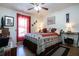 Bedroom with wood floors, ceiling fan, and large window with red curtains at 408 River Bed Ct, Wimauma, FL 33598
