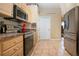 Well-lit kitchen with stainless appliances, neutral cabinets and stone-look tile floors at 408 River Bed Ct, Wimauma, FL 33598