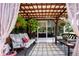 Outdoor lounge area with covered lattice pergola, comfortable seating, hanging plants, and a view of the screened-in patio at 408 River Bed Ct, Wimauma, FL 33598