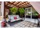 Inviting covered patio with a swing, ample seating, and lush greenery creating a relaxing outdoor space at 408 River Bed Ct, Wimauma, FL 33598