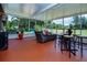 Spacious screened patio, perfect for entertaining, featuring outdoor furniture, high-top table and bar stools at 408 River Bed Ct, Wimauma, FL 33598