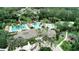 Aerial view of community, with clubhouse, pool, palm trees, playground, and surrounding greenery at 4116 Knollpoint Dr, Wesley Chapel, FL 33544