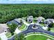 An aerial view of a neighborhood surrounded by lush greenery and mature trees on a sunny day at 4116 Knollpoint Dr, Wesley Chapel, FL 33544