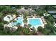 Aerial view of the community pool with lounge chairs, palm trees, and landscaped grounds at 4116 Knollpoint Dr, Wesley Chapel, FL 33544