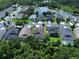 Aerial view of a neighborhood with homes nestled among lush greenery and a serene lake at 4116 Knollpoint Dr, Wesley Chapel, FL 33544