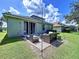 A scenic backyard scene featuring outdoor furniture and the home's exterior, ideal for lounging and enjoying at 4116 Knollpoint Dr, Wesley Chapel, FL 33544