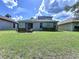 Expansive green backyard with patio area and outdoor seating, perfect for entertaining at 4116 Knollpoint Dr, Wesley Chapel, FL 33544