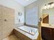 Corner bathtub featuring tiled surround at 4116 Knollpoint Dr, Wesley Chapel, FL 33544